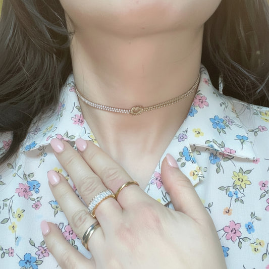 GLOW KNOT – Collana Asimmetrica in Acciaio con Doppia Veretta di Zirconi e Nodo Centrale – Eldra Milano