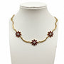 Collana essenzial curva flora | zirconi rossi e acciaio